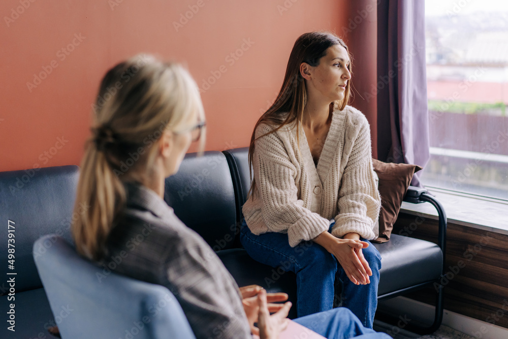 Sad frustrated woman talking in a session with a psychotherapist about her problems. Sad frustrated woman talking in a session with a psychotherapist about her problems.