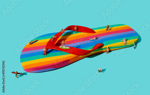 some miniature men on a rainbow flip-flop