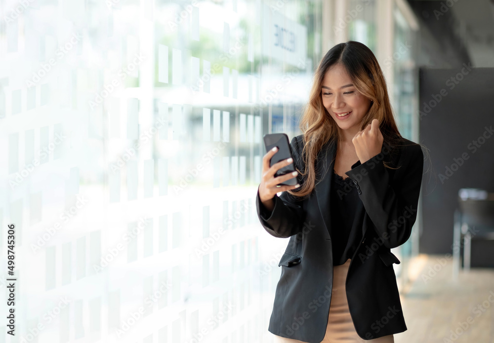 Beautiful asian woman using smartphone, exciting and celebrating with good news of business successful. Small business startup concept. Beautiful asian woman using smartphone, exciting and celebrating with good news of business successful. Small business startup concept.