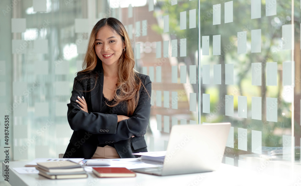 Fototapeta premium Image of a charming young Asian businesswoman standing at the office. Looking camera.
