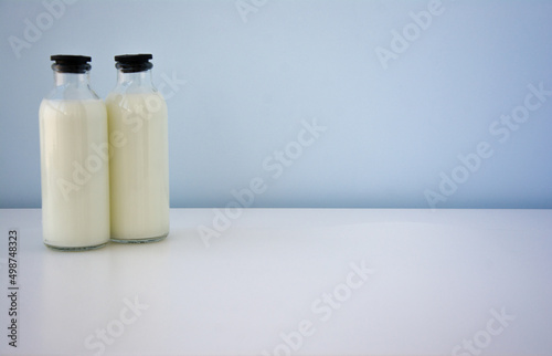 Milk bottle on white table with blue background.