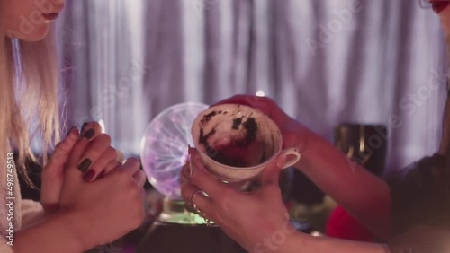 Close up of fortune teller explains fortune on Turkish coffee to her young client