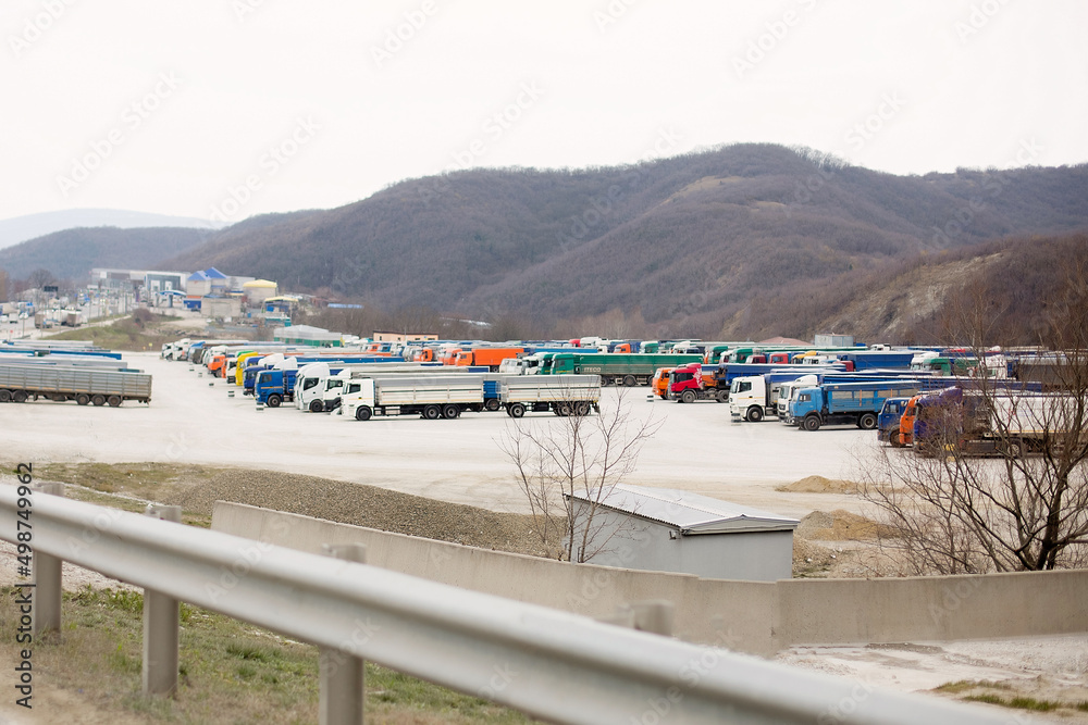 Panoramic view with a rest area of truck parking with trailers parked in a row next to the road. Panoramic view with a rest area of truck parking with trailers parked in a row next to the road.