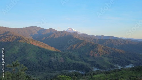 Aerial drone shot of beautiful lighting green mountains and famous Sangay Volcano in background 