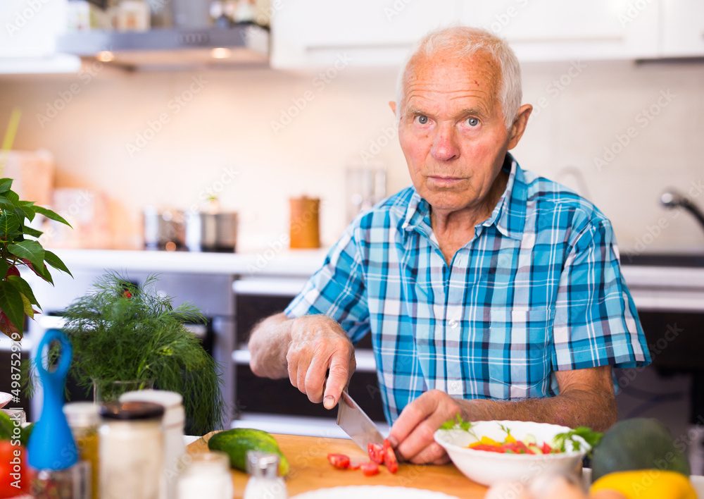 senor man preparing fresh vegetable salad at home in the kitchen senor man preparing fresh vegetable salad at home in the kitchen