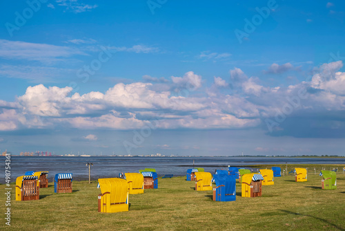 Beach chairs at the North Sea on the beach of Butjadingen Germany under a white-blue sky