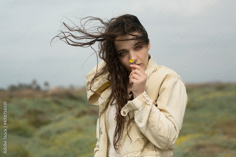 Sesión otoñal con chica joven morena de piel clara y pelo largo durante un día nublado en paisaje natural. 