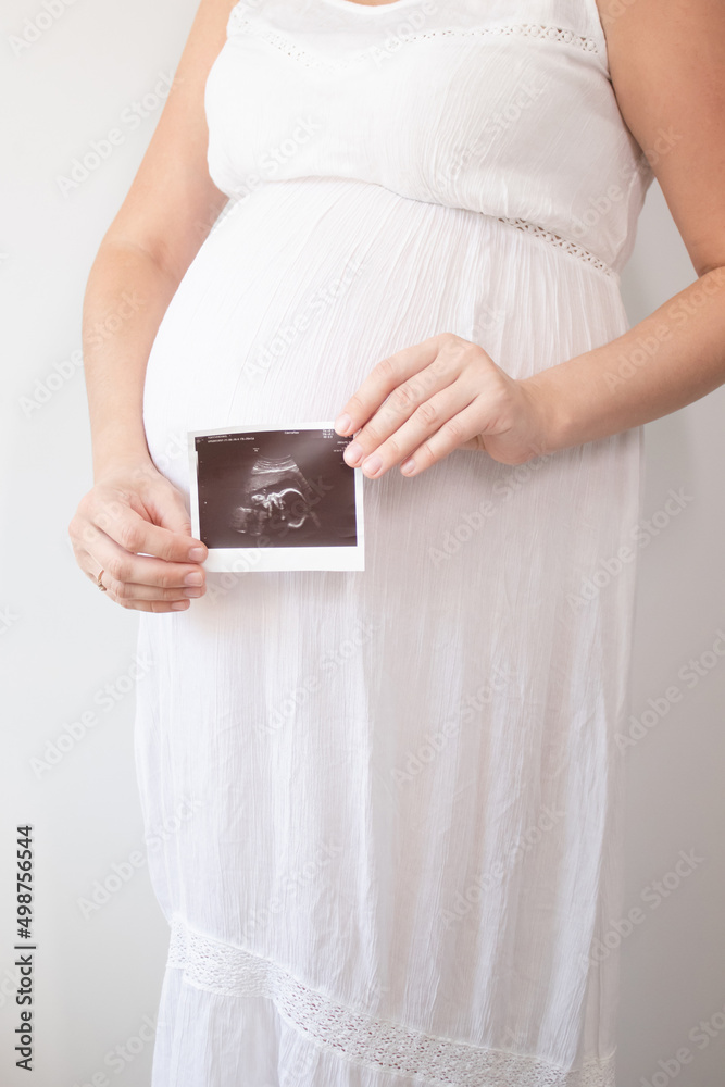 pregnant woman with a photo of ultrasound of pregnancy. enjoying pregnancy happy time. mother to be with cute big tummy pregnant woman with a photo of ultrasound of pregnancy. enjoying pregnancy happy time. mother to be with cute big tummy