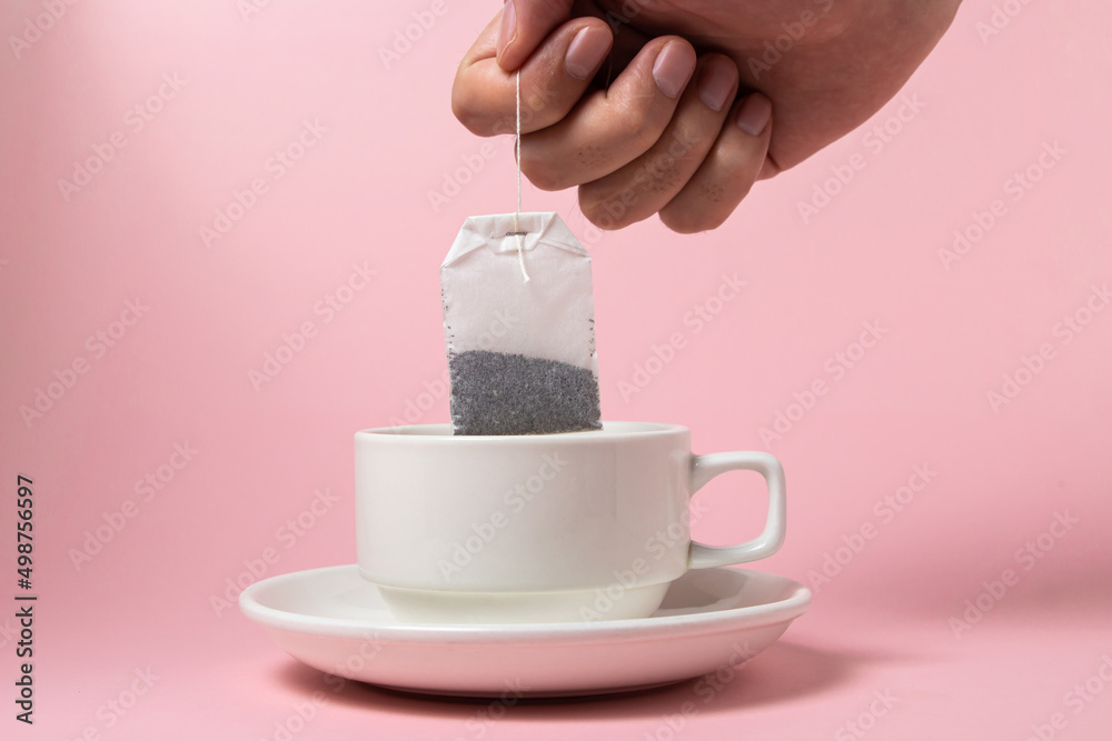 Tea bag in a white cup on a pink background. A quick and easy way to ...