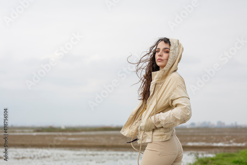 Sesión otoñal con chica joven morena de piel clara y pelo largo durante un día nublado en paisaje natural.  photo