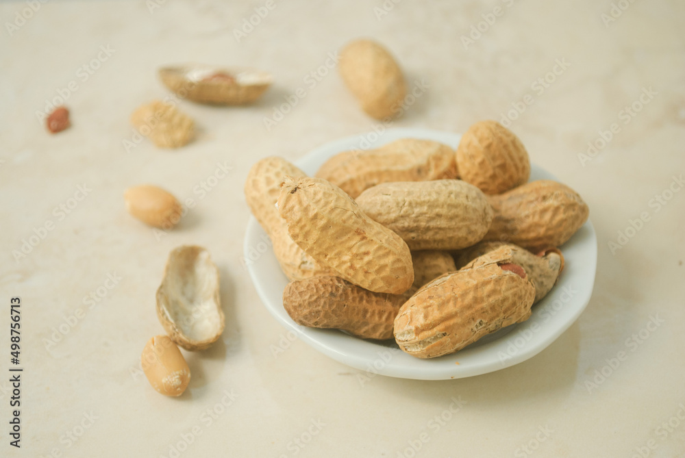 peanuts in a white plate on a kitchen top peanuts in a white plate on a kitchen top