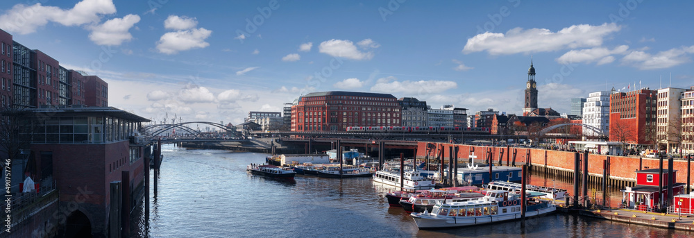 Cityscape of Hamburg, Germany, on the sunny day. Wide panoramic view on the city center, Hafencity, Hauptkirche St. Michaelis with the harbor in the foreground and Hamburg port in the background