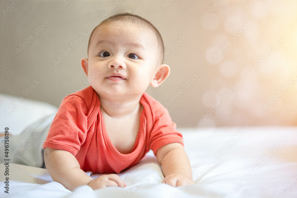 Happy family, Cute Asian newborn baby wear red shirt lying, crawling, play on white bed with laughing smile happy face. Little innocent infant adorable child in first day of life. Mother Day concept. Happy family, Cute Asian newborn baby wear red shirt lying, crawling, play on white bed with laughing smile happy face. Little innocent infant adorable child in first day of life. Mother Day concept.