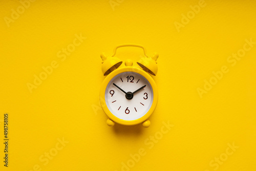 Yellow alarm clock on a yellow background close-up