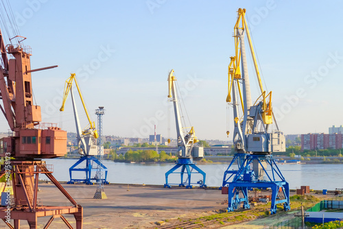 Cargo cranes in the Yenisey river port in Krasnoyarsk, Russia. Industrial urban background