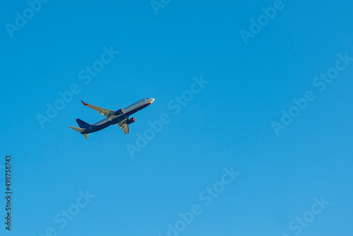 Blue passenger plane against the blue sky.