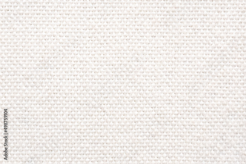 White wool braided area rug texture background, bathroom carpet. Close-up, top view.