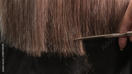 Stylist cuts hair with scissors in salon. barber haircuts for women. master makes fashionable haircut. Close up of hairdresser cutting hair