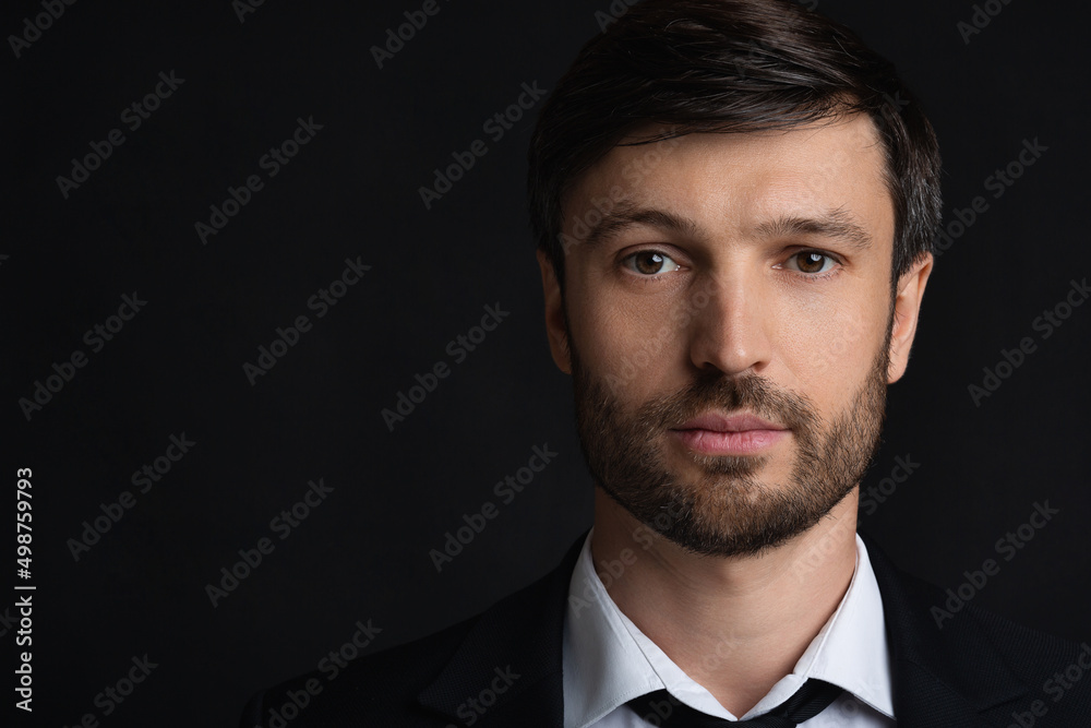 Portrait Of Confident Businessman Looking At Camera Over Black Background Portrait Of Confident Businessman Looking At Camera Over Black Background