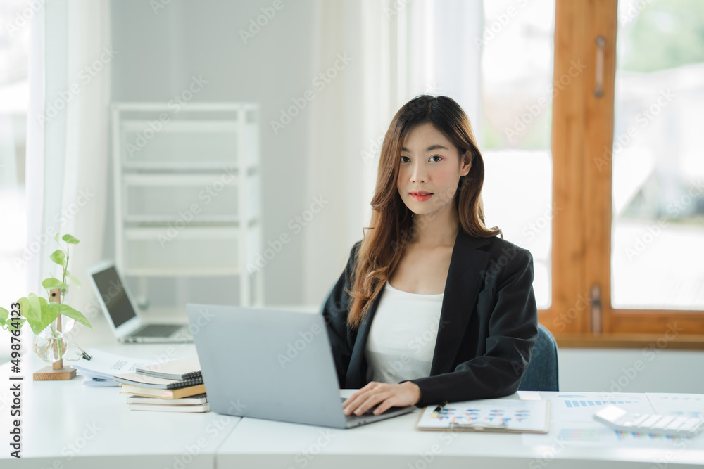 Asian woman working in the office using a laptop. Asian woman working in the office using a laptop.
