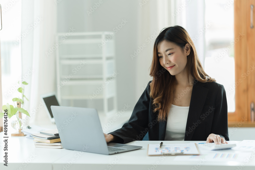 Portrait of Asian young female working on laptop and financial report at office. Portrait of Asian young female working on laptop and financial report at office.