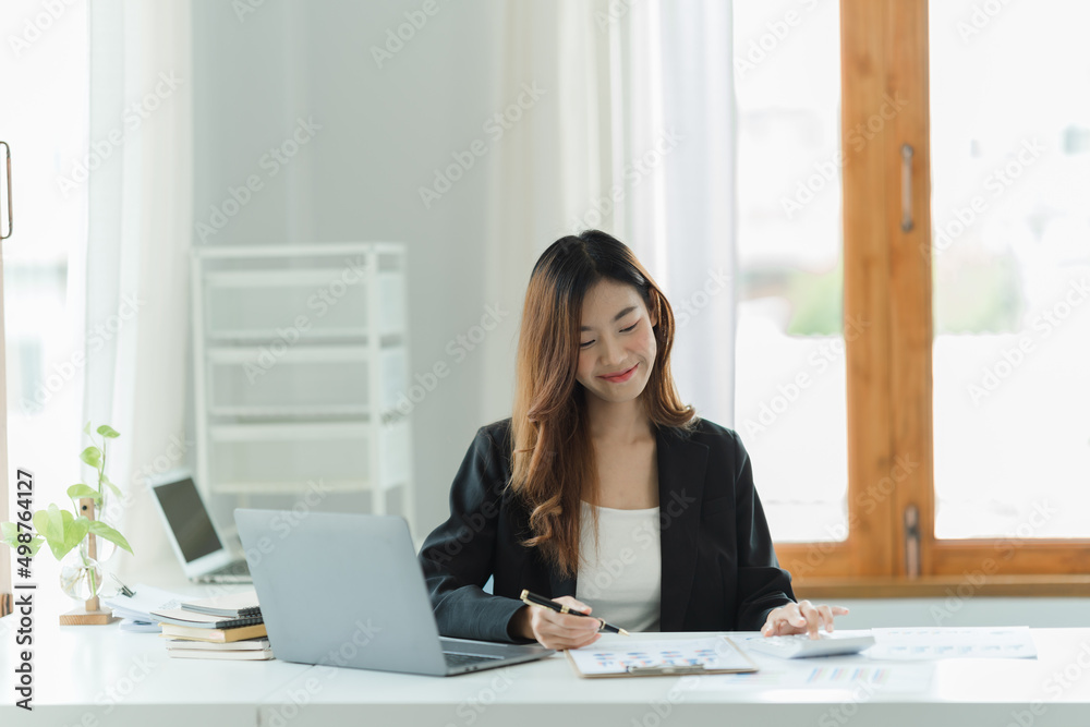 Asian woman working in the office using a laptop. Asian woman working in the office using a laptop.