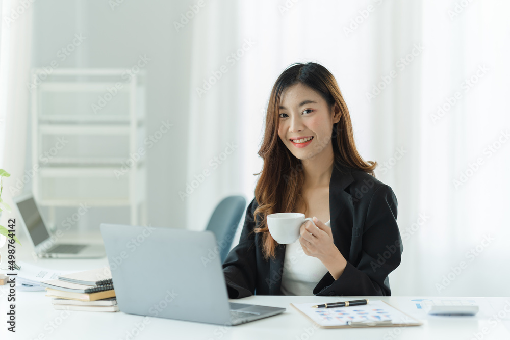 Beautiful young asian woman drinking coffee in modern office. Beautiful young asian woman drinking coffee in modern office.