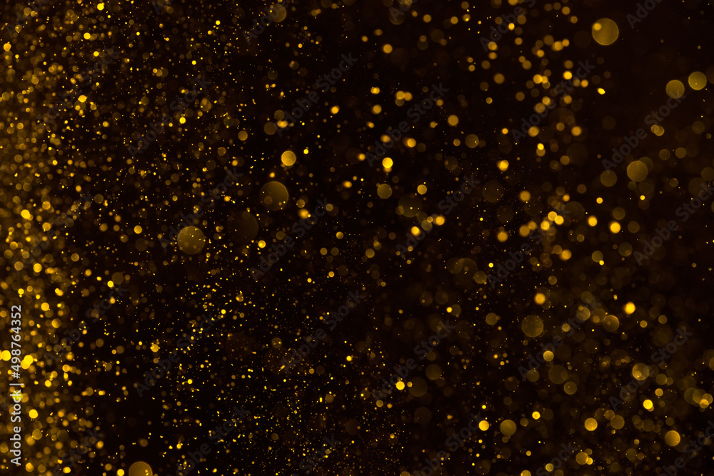 Abstract golden glitter shiny particles lights dark bokeh pattern background Abstract golden glitter shiny particles lights dark bokeh pattern background