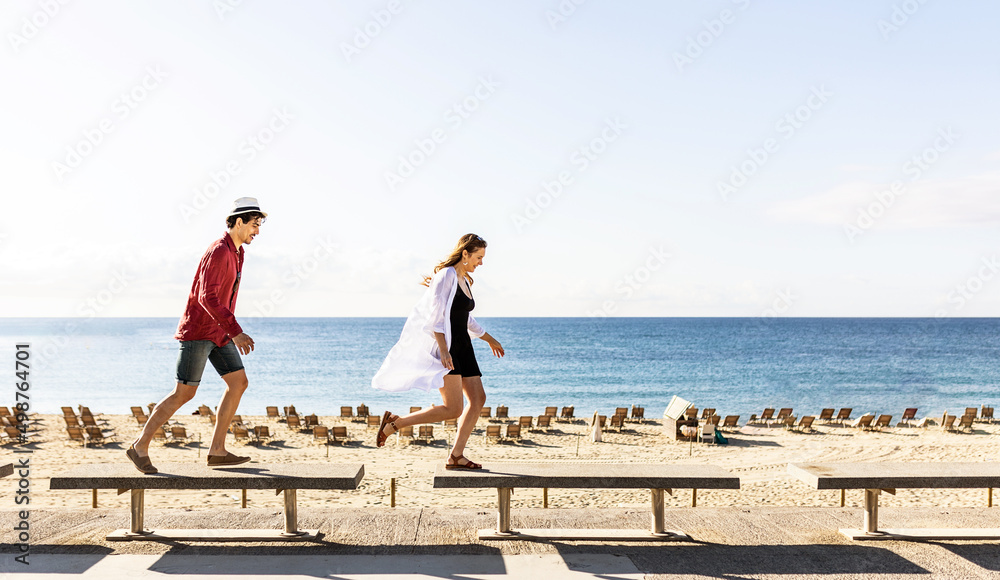Happy young couple having fun together while enjoying summer vacations at the beach in Barcelona. Travel and relationship concept. Copy space for text