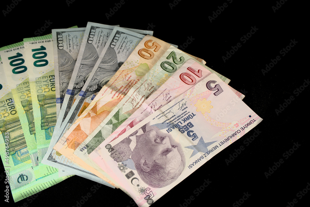 Turkish lira banknotes and American dollars on a black background Turkish lira banknotes and American dollars on a black background