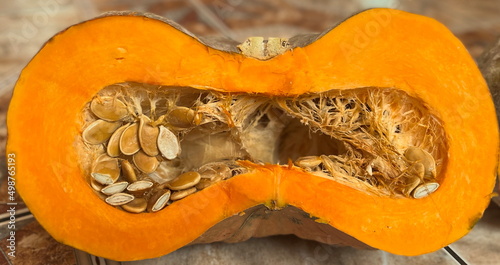 Pumpkin seeds are edible, flat, oval-shaped seeds found at the centre of the pumpkin fruit. Half of bright orange pumpkin. Raw pumpkin is a healthy snack