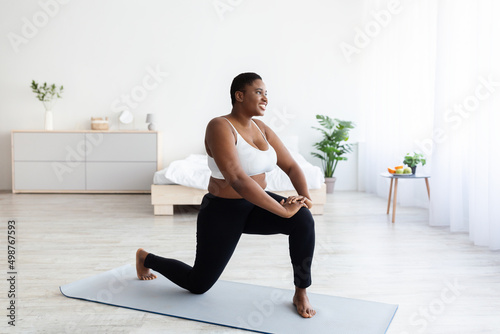 Effective bodyweight exercises. Overweight young black woman making domestic workout, copy space