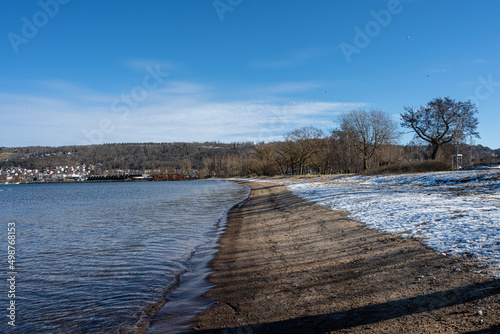 A winter beach covered with snow and a blue sky in the background © Dan