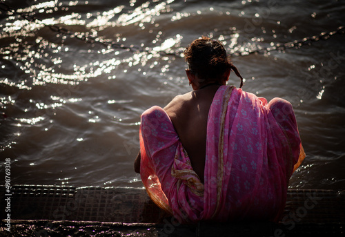 Mujer meditando en el rio ganges   photo