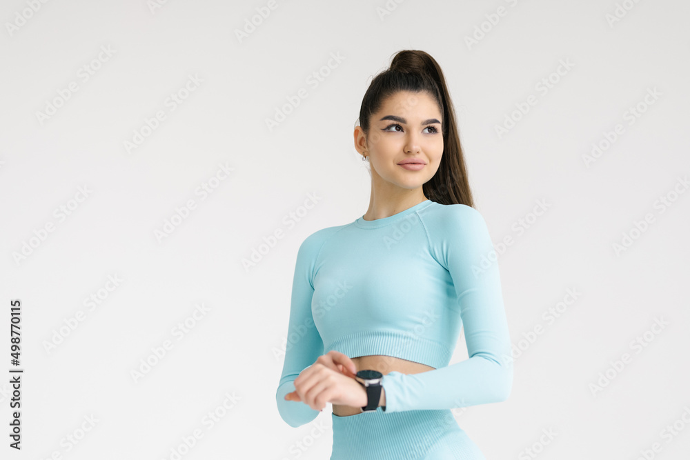 Attractive woman looking at fitness tracker and loss calories on white background Attractive woman looking at fitness tracker and loss calories on white background