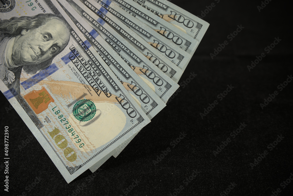 one hundred dollars close up on black background one hundred dollars close up on black background