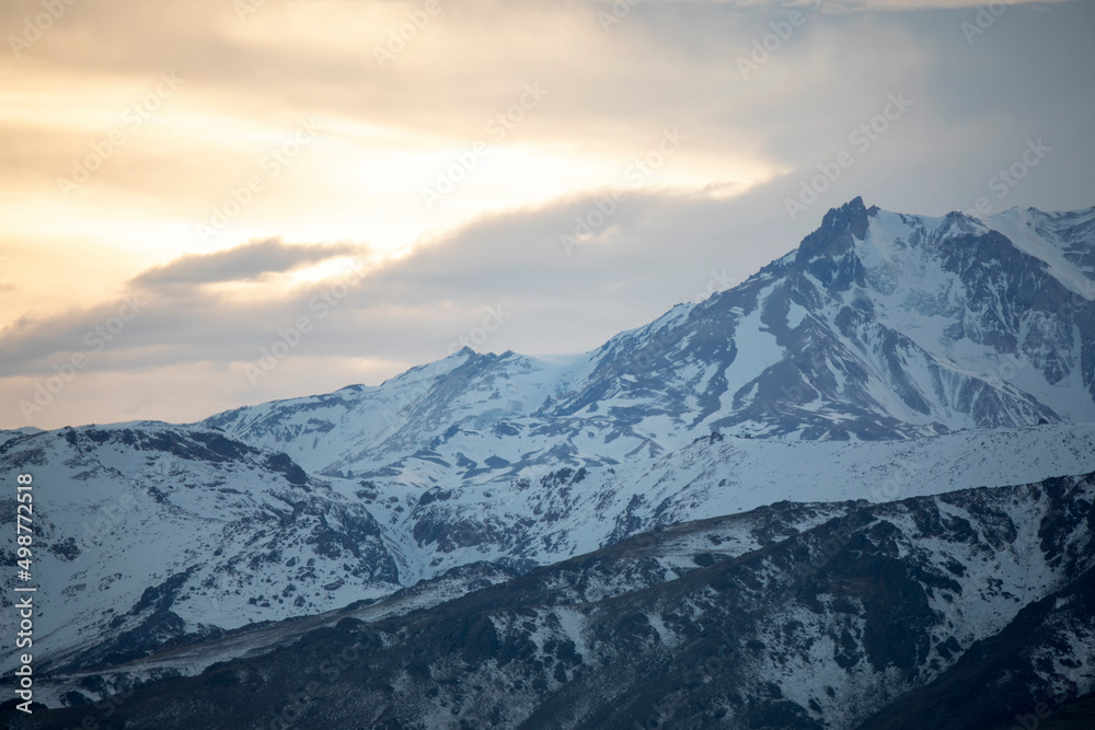Alpine landscape. View of volcano Domuyo at sunset. The Andes mountains with rocky peaks covered with snow at sunrise.