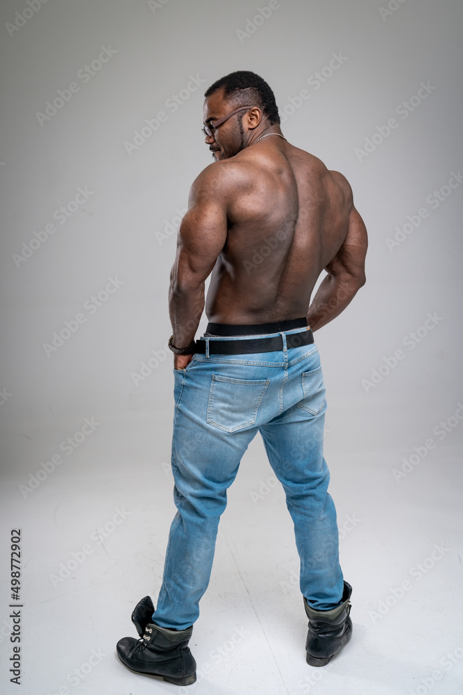Fototapeta premium Young bodybuilder with athletic torso. Muscular strong man posing in studio.