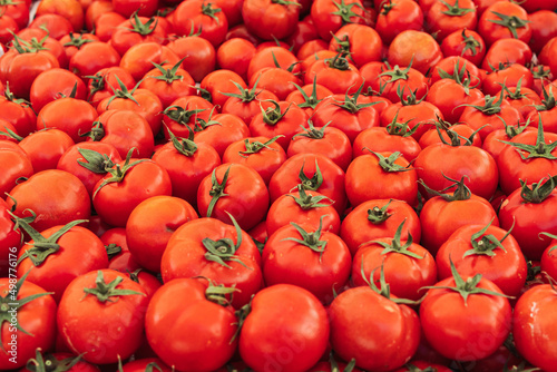 a lot of tomatoes on the market on the counter  the background