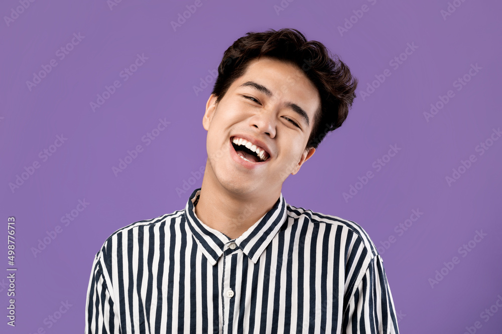 Portrait of smiling Asian guy posing laughing at studio Portrait of smiling Asian guy posing laughing at studio