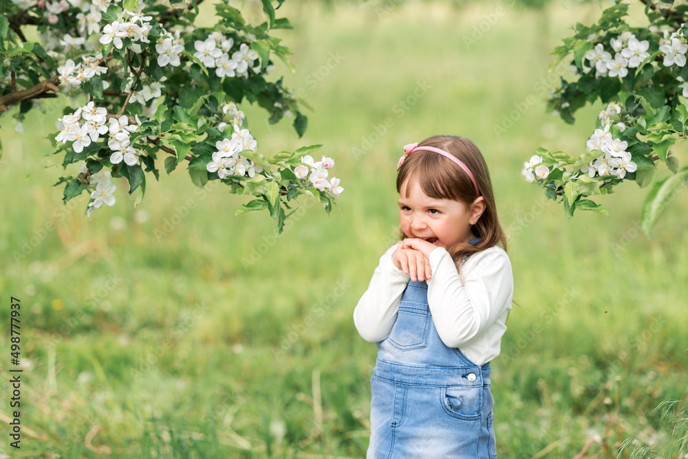 Portrait of a girl in a spring garden near blooming apple trees Portrait of a girl in a spring garden near blooming apple trees