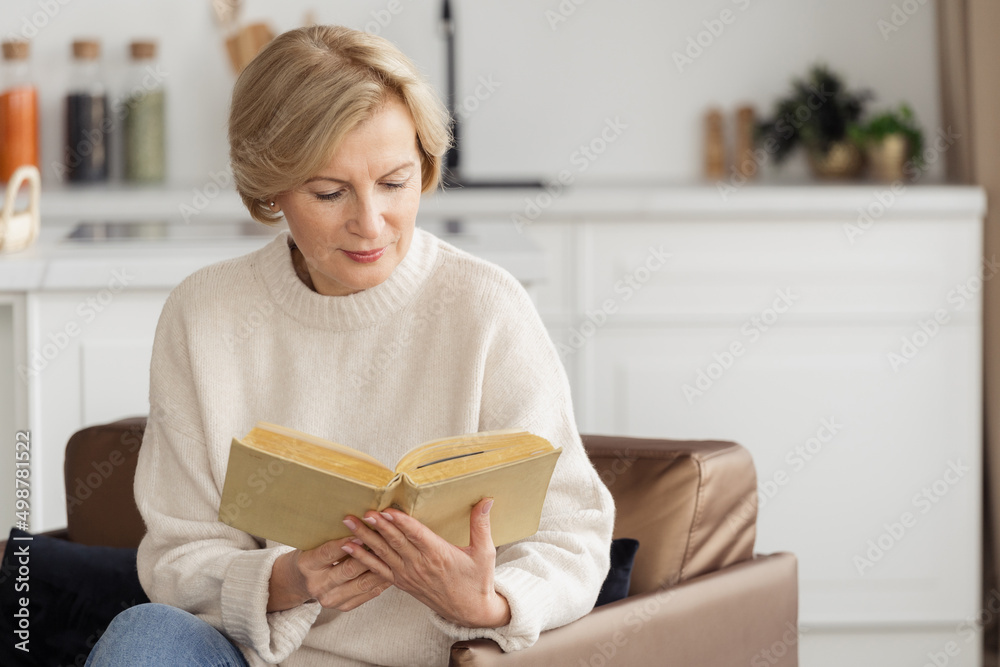 Mature woman reading book while she resting at home Mature woman reading book while she resting at home