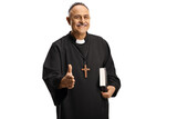 Happy priest gesturing handshake and holding a bible