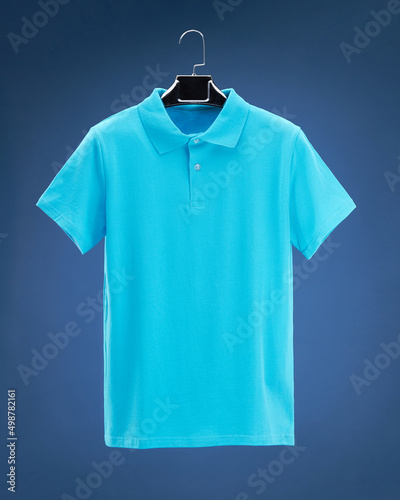 Wallpaper Mural Dimensional polo shirt hanging on hanger, dark blue background colours, turquoise, emerald, blue. Torontodigital.ca