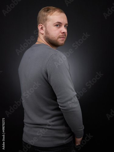 vertical portrait  blond man on a dark background, in a jacket © justoomm