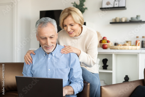 Photos Mature family couple watching video on laptop