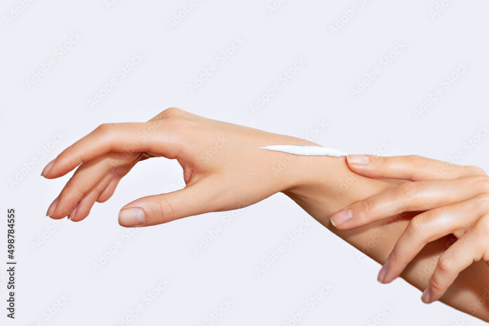 Female hands with a moisturiser on light background. Close-up of Woman Applying Cream on Hand. Hands Skin Care. Female hands with a moisturiser on light background. Close-up of Woman Applying Cream on Hand. Hands Skin Care.