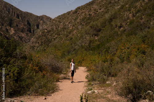 Hiking across the forest and hills. View of a woman trekking along the path across the mountains and grassland.  © Gonzalo