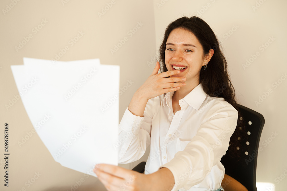 Applicant with laptop holds papers with exam results in his hands and rejoices. Student girl passed exam and rejoices at high mark. Online education and distance learning. Applicant with laptop holds papers with exam results in his hands and rejoices. Student girl passed exam and rejoices at high mark. Online education and distance learning.