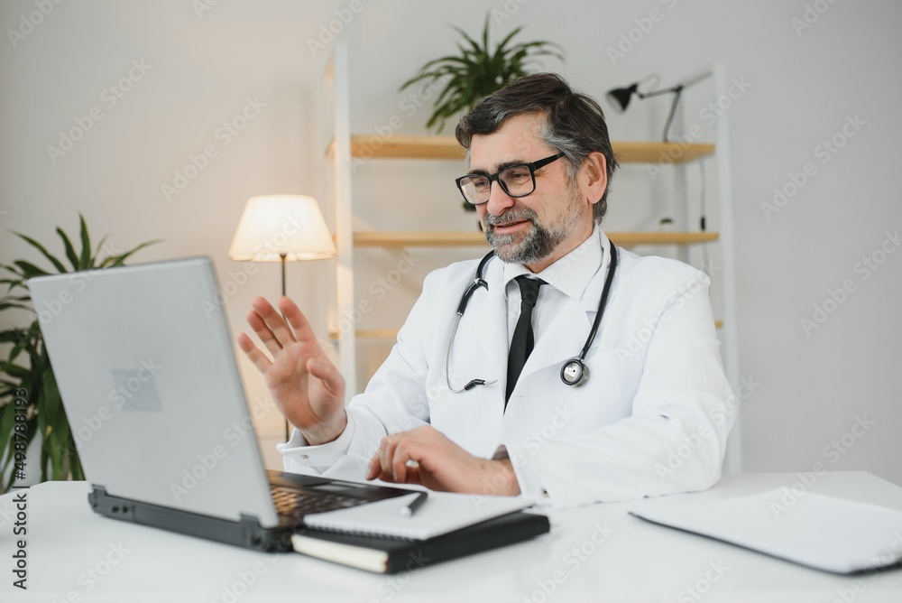 Portrait of senior doctor in white coat at workplace. Portrait of senior doctor in white coat at workplace.